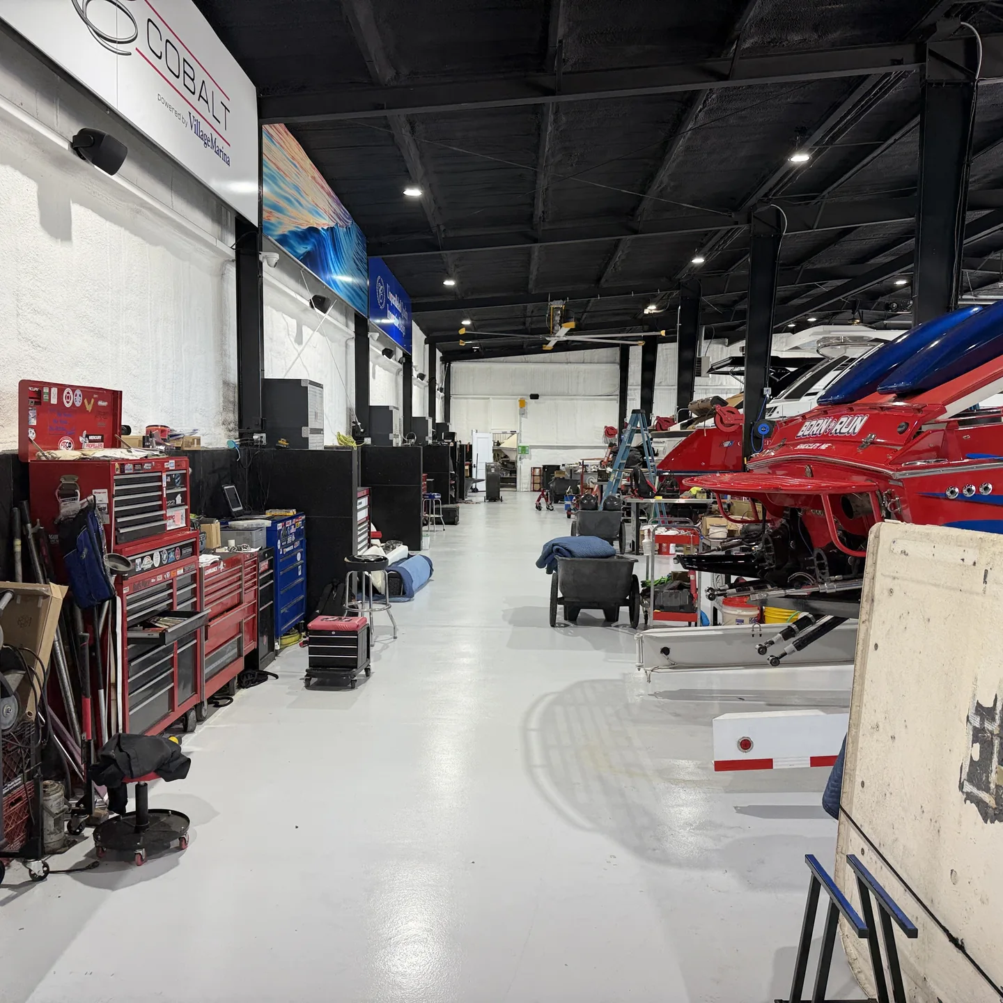 Village Marina workshop with tool stations and boats in service bays